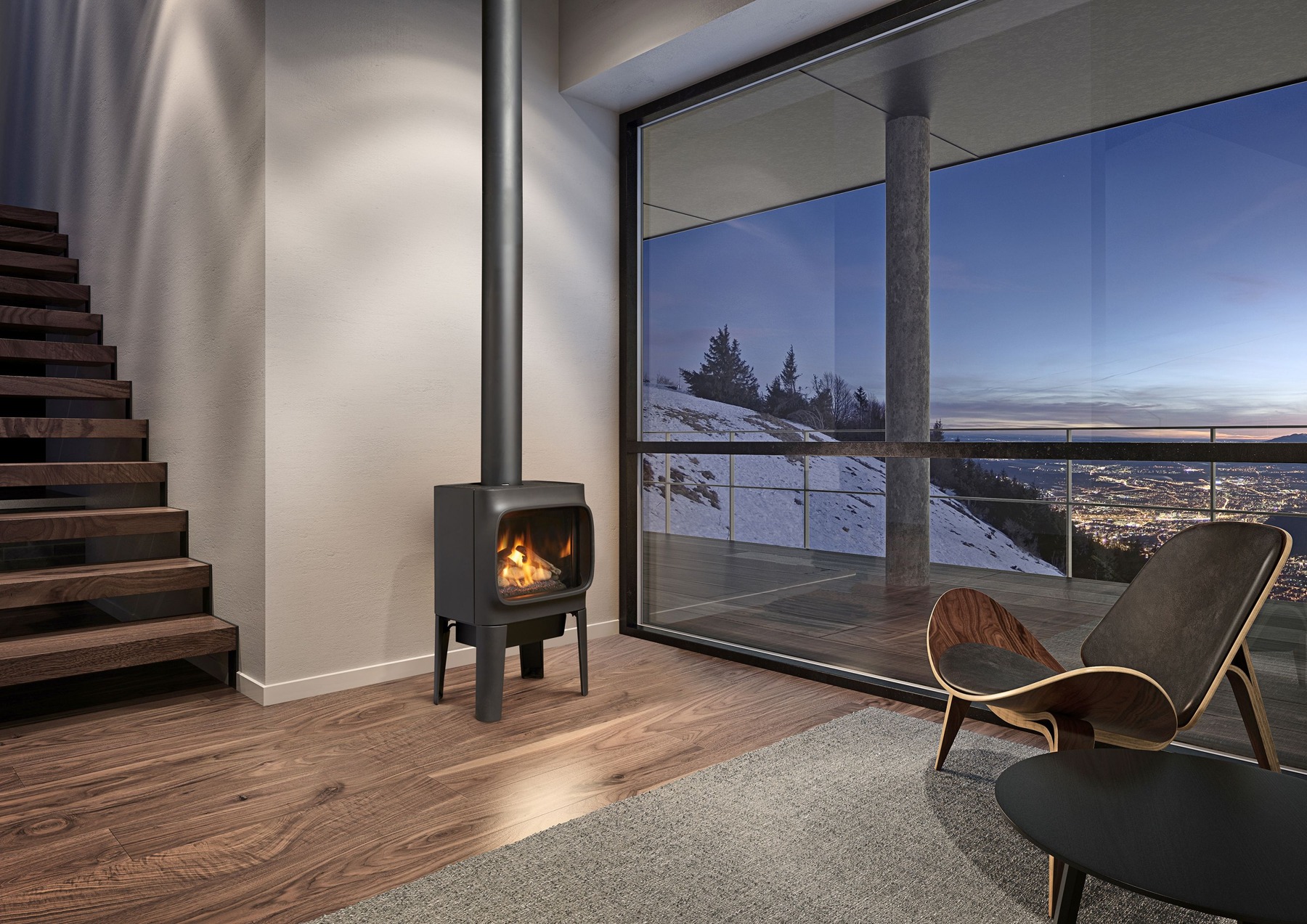 Freestanding Jøtul GF 305 gas stove beside a staircase and large snowy-view windows