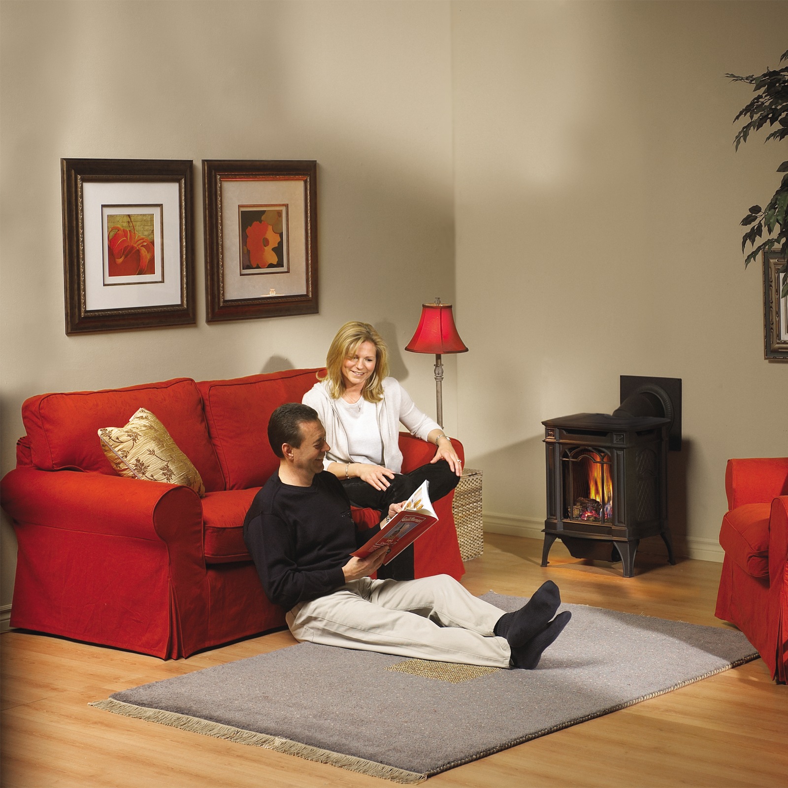 Napoleon Arlington cast-iron freestanding gas stove in a family living room with a red sofa